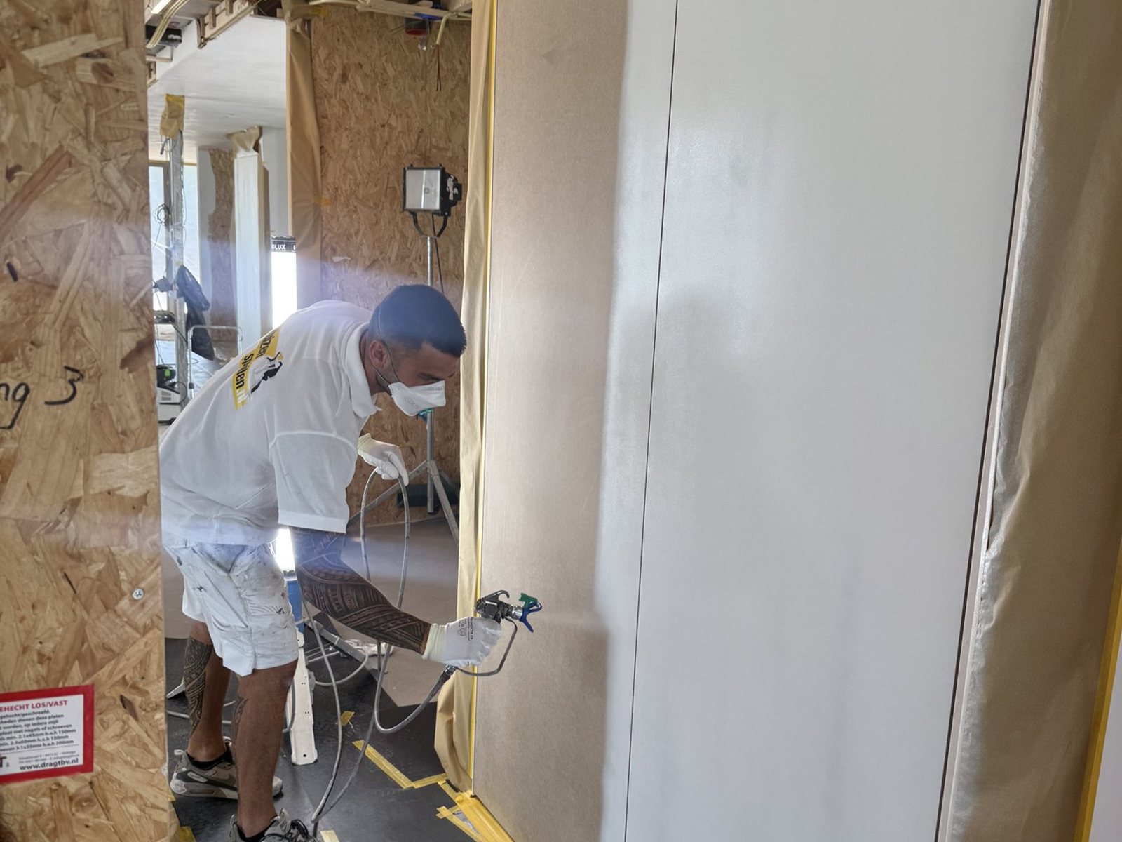 Vakman spuit lak op houtwerk met een airless spuitpistool